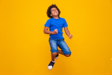 little afro boy jumping on yellow background.