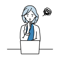 デスクで座ってPCを開いて困っているジャケットの女性