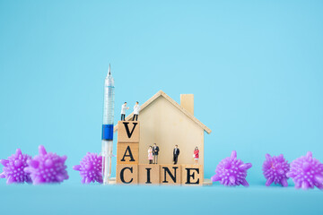 miniature doctor , patient , home , purple virus and syringe with Wooden cubes with words...