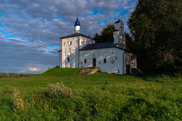 Fototapeta na wymiar Saint Nicholas Church in Gorodishche (Nikolskaya church) on Truvorov Gorodishche on a sunny summer evening with clouds. Stary Izborsk, Pskov region, Russia
