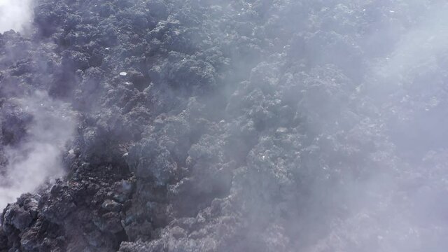 Avachinsky drone volcano summit video. Kamchatka, active volcano, red soil, steam, solidified black lava, sulfur