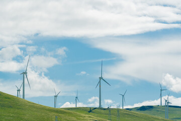 A set of wind turbines on hills of grasslands.