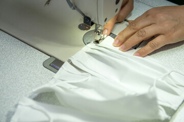 Obraz na płótnie Canvas A sewing factory makes masks for coronavirus using sewing equipment.