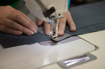A seamstress at the factory makes knitwear.