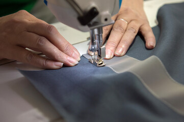 A seamstress at the factory makes knitwear.