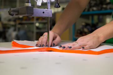 sewing workshop, cutting fabric to a given size.