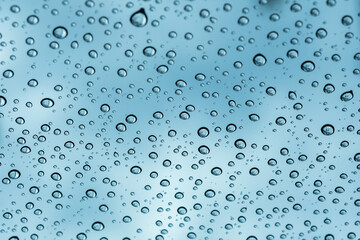 Fototapeta na wymiar rain drop on the window with blue sky and cround