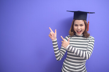 Portrait of young woman graduated over blue background