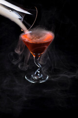 red alcoholic cocktail with smoke from the bar