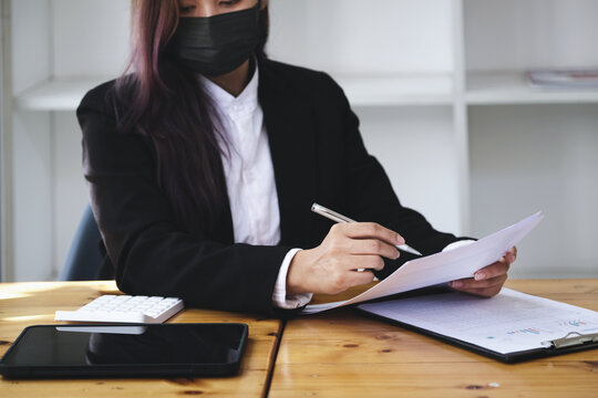 A businesswoman is researching earnings affected by the coronavirus pandemic to adjust her market strategy.