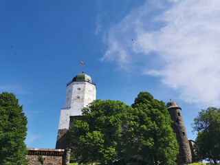 The walls of Vyborg Castle and the Tower of St. Olaf in the city of Vyborg against the blue sky.