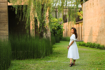Beautiful Asian woman walking in the garden with sun light in evening.