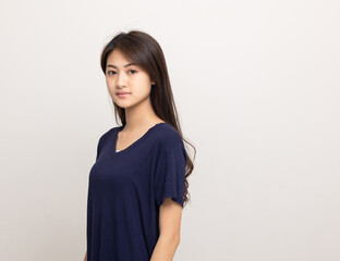 Obraz premium Beautiful young asian woman standing on isolated white background. Thai Teenage girl around 20 looking at camera.