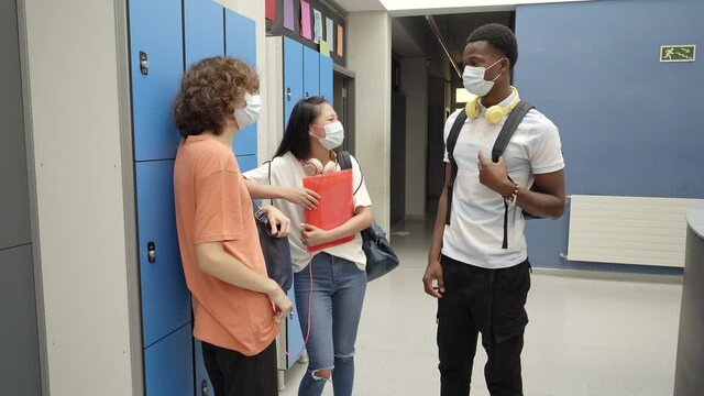 Back to class of young students wearing masks to protect themselves from the coronavirus pandemic. New normality in high schools.