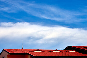 the fluffy clouds with  blue sky over the roof top 