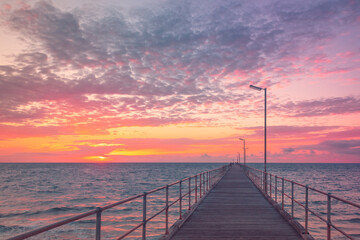 Port Noarlunga jetty with people during pink sunset, South Australia