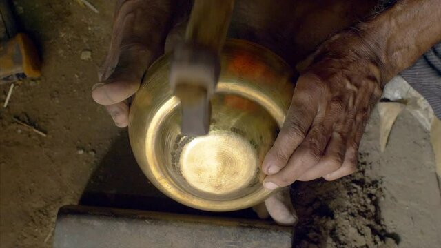 A skilled man designing utensils with the age-old art of crafting wares in India. 