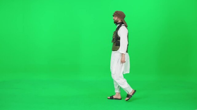 A man of Arab appearance in traditional clothes, passer-by walking down the street against the green background, man in military uniform, chromakey template.