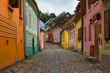 Fototapeta na wymiar ルーマニア　トランシルヴァニア地方のシギショアラの歴史地区の町並み　カラフルな家と石畳の路地
