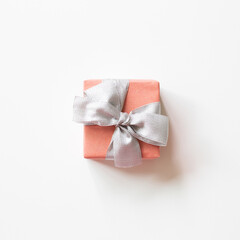 Pink gift box with silver ribbon isolated on white background. top view, copy space