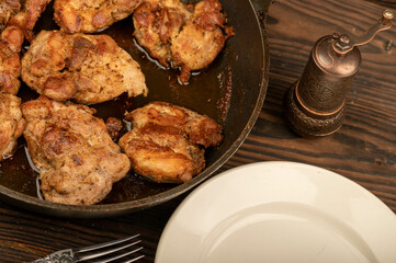 Fried pieces of meat in a frying pan, close-up, selective focus.