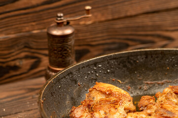 Fried pieces of meat in a frying pan, close-up, selective focus.