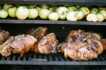 Grilling food. The meat is barbecued with coals. Pork knuckle with apples on the barbecue.