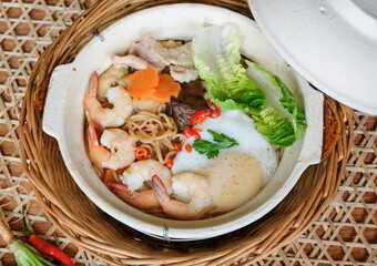 Homemade Chinese cuisine. Claypot Yee Mee Noodle Soup. Broth made from chicken carcass, dried noodle, fresh prawns, pork slices, mushrooms, deep fried tofu skin, tofu pouch, vegetables and poached egg
