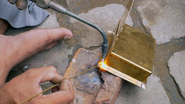 A skilled worker is brazing the metal  . 