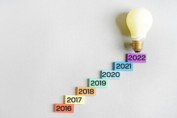 Figures denoting years 2016-2022 and light bulb on grey background