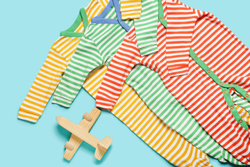Fototapeta premium Stylish baby clothes with toy on color background