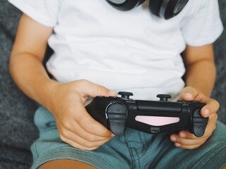boys children play computer games on video consoles with joysticks