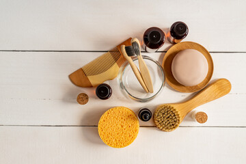 Natural serum, dry soap, sponges and face massaging brush with natural bristle on a table. Presentation of organic eco friendly spa beauty products in neutral colors nature environment