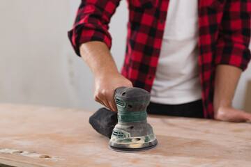 close up of man working with electric sander