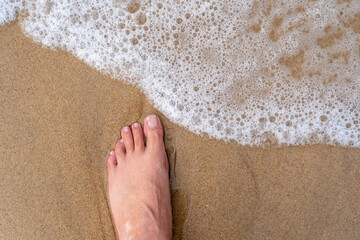 pie sobre la arena fina de una playa rozando al agua del mar, paseando por la playa