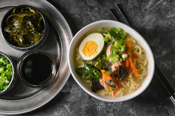 Composition with tasty Chinese soup on dark background