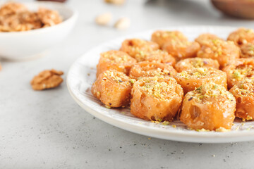 Plate with delicious baklava on light background, closeup