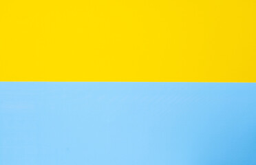 Yellow-blue background bisected vertically. Blue and yellow sheet of paper, copy-space