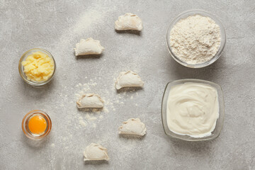 Composition with raw dumplings on grey background