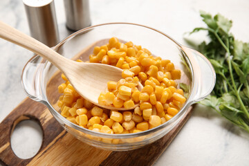 Bowl with corn kernels on light background, closeup