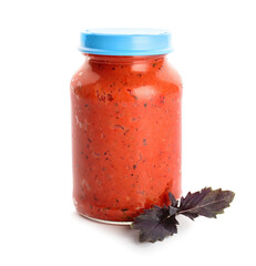 Jar of tasty pesto sauce on white background