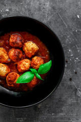 Chicken meatballs with basil and tomato sauce. Dark background. Copyspace. Meatballs with tomato and chili. Top view