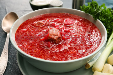 Bowl of tasty borscht on dark background, closeup