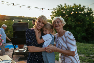 Portrait of three female members of family. Child, mother and grandmother hugging together in the...