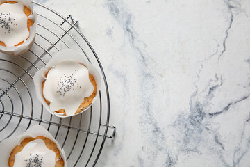 Cooling grid with delicious glazed poppy seed muffins on light table