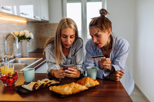 Lovely Lesbian Couple Doing Online Shopping At Home.