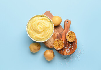 Fototapeta na wymiar Bowl of tasty mashed potatoes with garlic on color background
