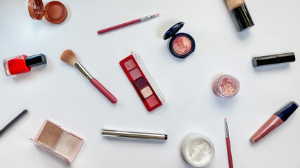 Beauty concept. Makeup products shadows, highlighter, blush, brushes, powder, glitter, mascara, gloss, lipstick, pencil on white background