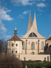 Benedictine monastery Emauzy, frontal view. Architectural monument from fourteen century with two modern spiky towers on sunny day, Prague, Czech Republic