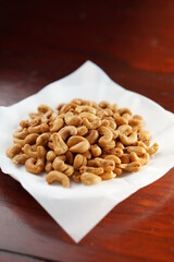 Deep fried cashew nuts in fried pad and dish with wood table.